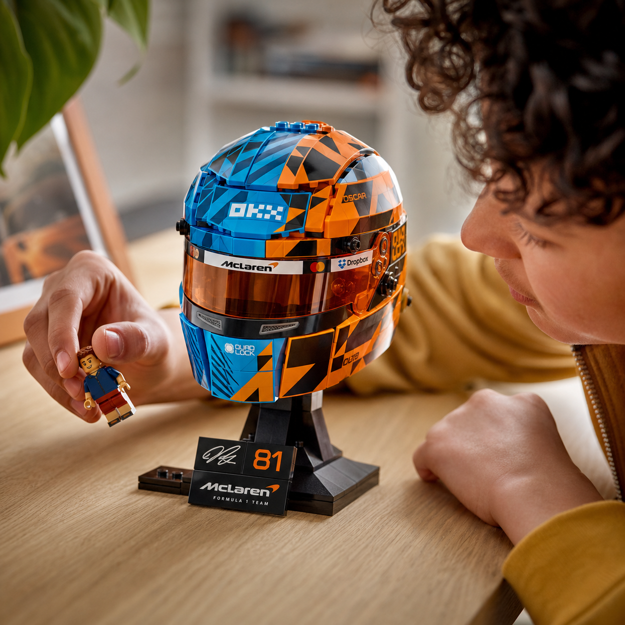 Capacete McLaren Oscar Piastri em vitrine de colecionador com luz cinematografica