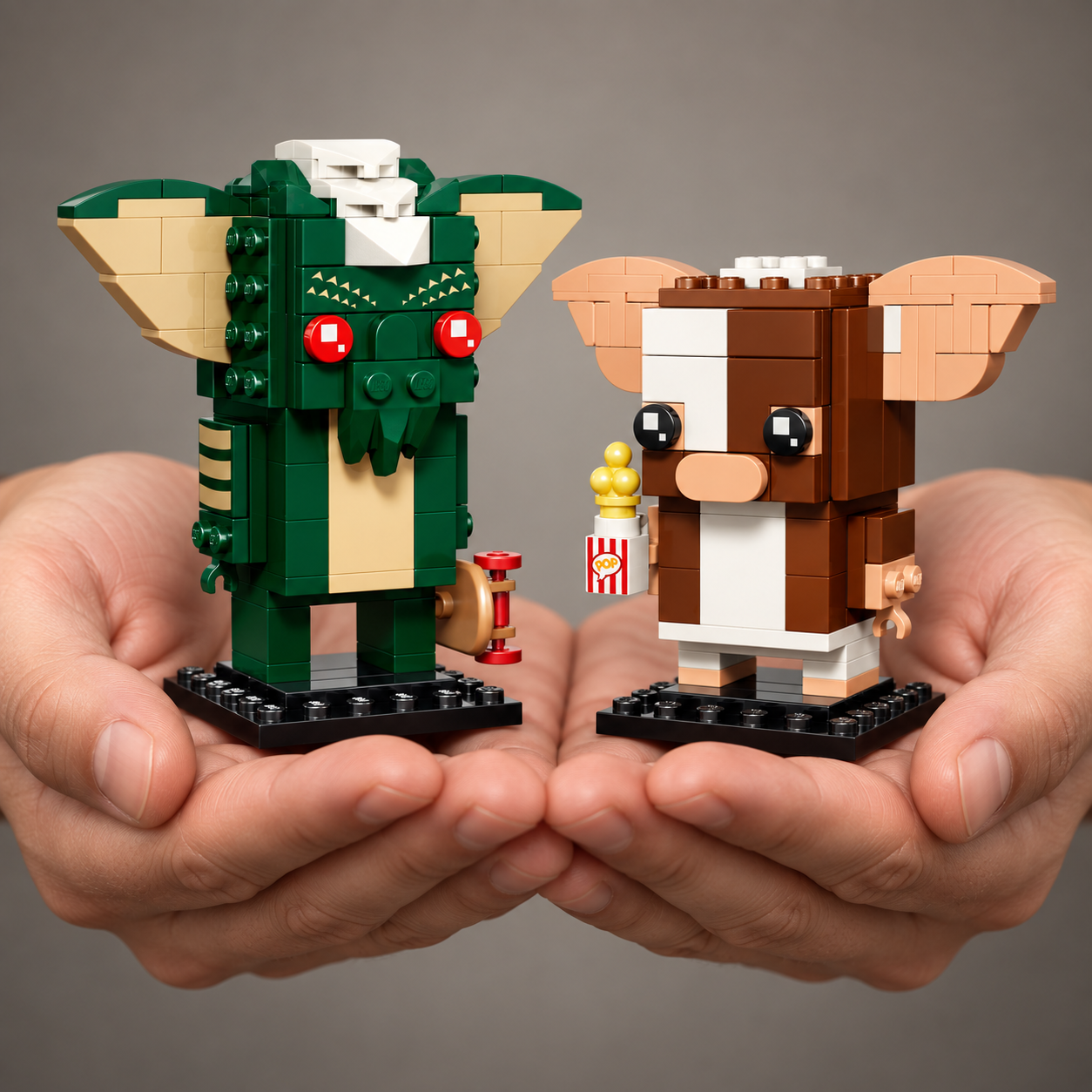 Gremlins - Figuras de Gizmo e Stripe (230 pe&ccedil;as): m&atilde;os segurando o modelo em escala real.